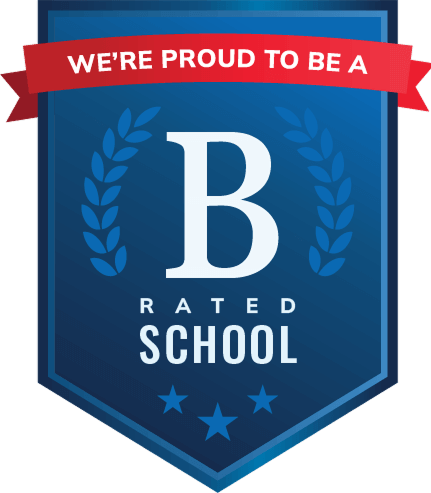 A dark blue badge icon with a red ribbon on top that says, "We're proud to be a", and underneath the ribbon there is a capital letter B and underneath the B, it says, "Rated school." 3 stars on the bottom and 2 vines surrounding the letter B.