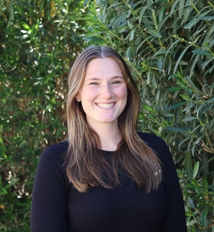 A headshot of Madison Cunningham in front of a bush