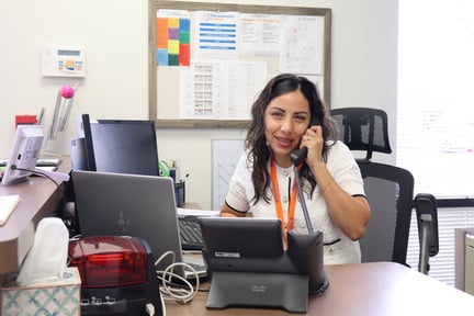 Admin assistant sitting at a desk and talking on the phone
