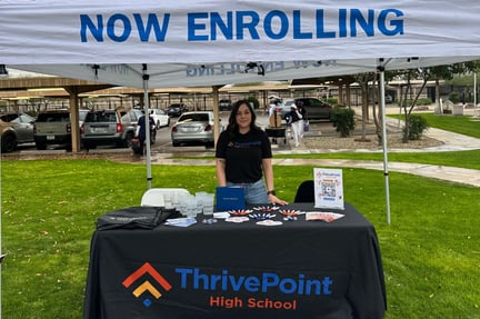 Learning Center Coordinator standing at a ThrivePoint booth for enrollments