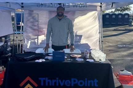 Mr. Roebuck standing behind a table that has ThrivePoint swag