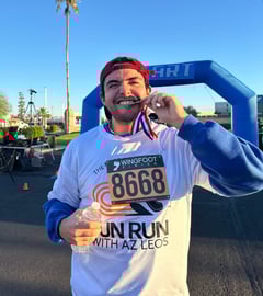 Mr. Searing biting his metal from a 5k run at a school community event
