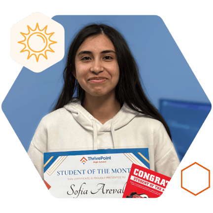 Student smiling and holding a raising canes gift card for winning student of the month