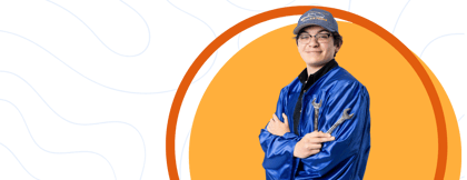 Student in a graduation gown holding tools