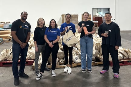 staff standing next to the tree care kits they assembled