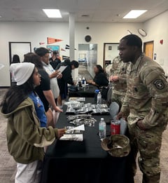student speaking with a man in a military uniform