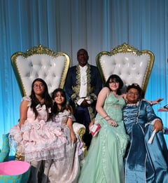 students at prom wearing dresses sitting on big chairs