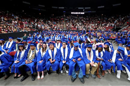 students in blue cap and gowns at the graduation ceremony