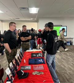 two students talking to two military recruiters